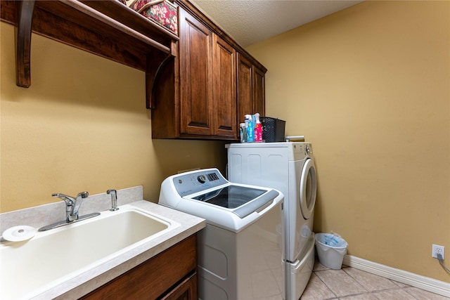 3630 Darnell Dr, Paris, TX 75462 - laundry area featuring separate washer and dryer, cabinet space, light tile patterned flooring, baseboards, and a textured ceiling