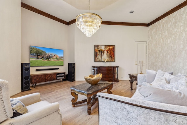 living room with wood finished floors, visible vents, and ornamental molding