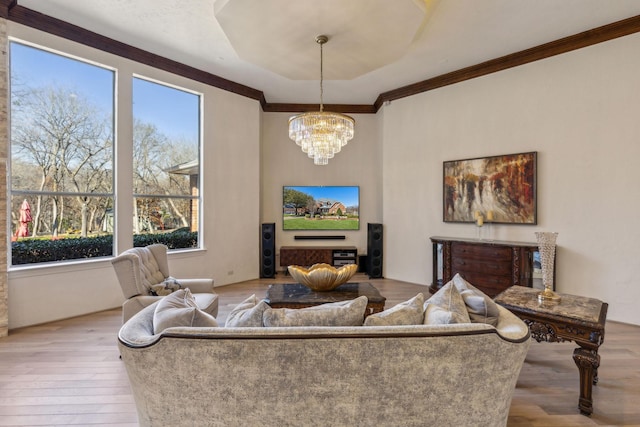 living area featuring wood-type flooring, a chandelier, and ornamental molding