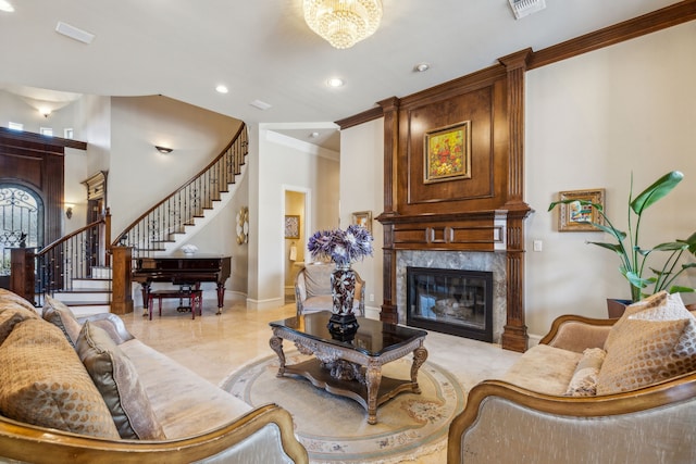 living room featuring visible vents, ornamental molding, a premium fireplace, baseboards, and stairs