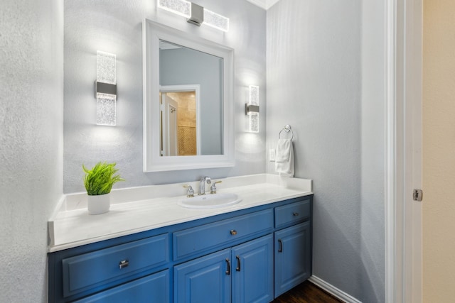 bathroom with vanity and a textured wall