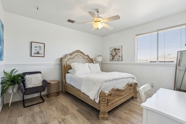 bedroom with ceiling fan, visible vents, and light wood-type flooring