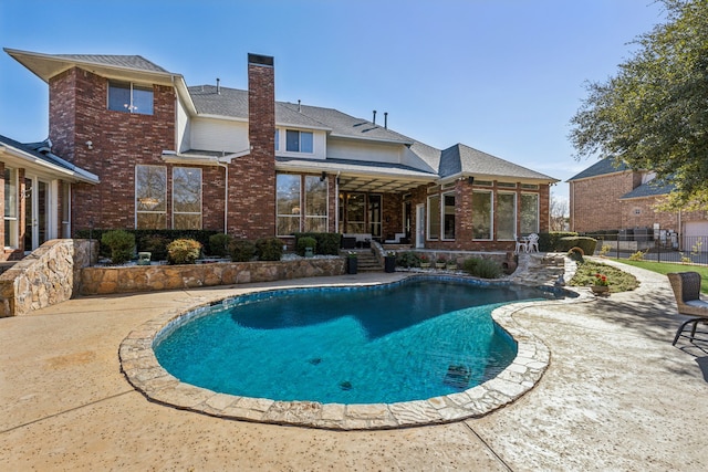 view of swimming pool with a fenced in pool, a sunroom, a patio, and fence