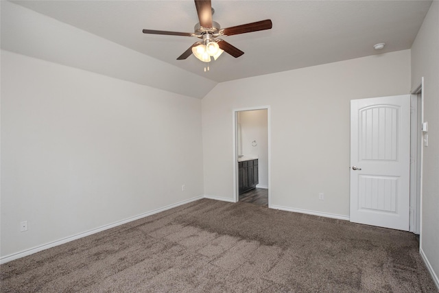 unfurnished bedroom featuring carpet floors, a ceiling fan, vaulted ceiling, ensuite bath, and baseboards