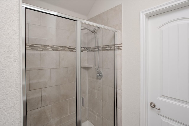 full bathroom with a textured wall and a shower stall