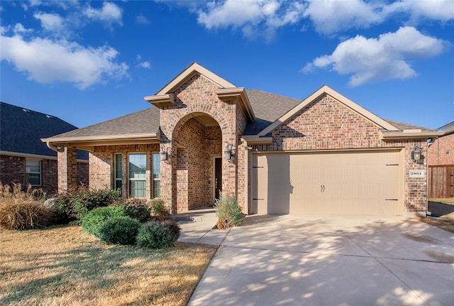 view of front of property featuring a garage, concrete driveway, brick siding, and a shingled roof