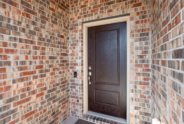 doorway to property with brick siding