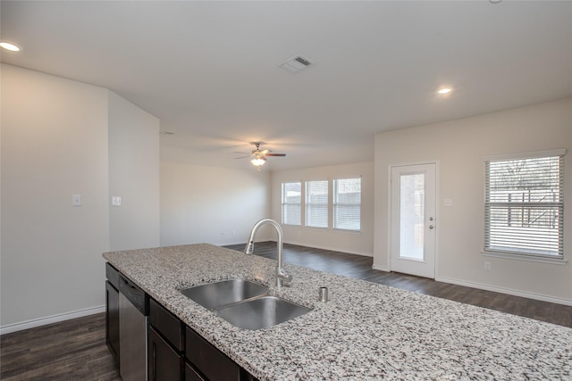 kitchen featuring light stone counters, a sink, visible vents, open floor plan, and dishwasher