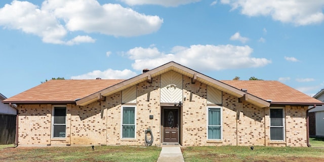 view of front of home featuring a shingled roof and brick siding