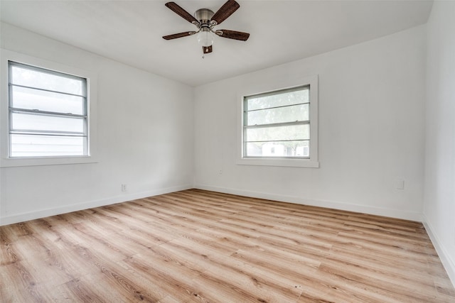 empty room with ceiling fan, light wood-style flooring, and baseboards