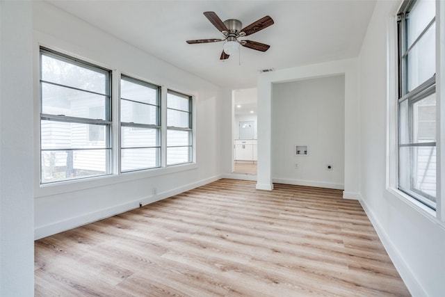 empty room with visible vents, ceiling fan, light wood-style flooring, and baseboards