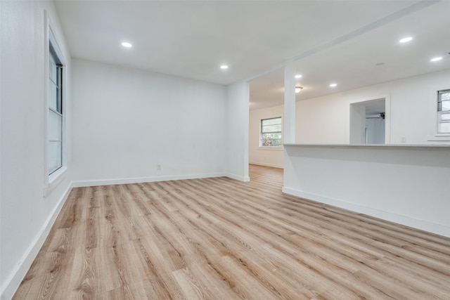 spare room with baseboards, light wood-style flooring, and recessed lighting