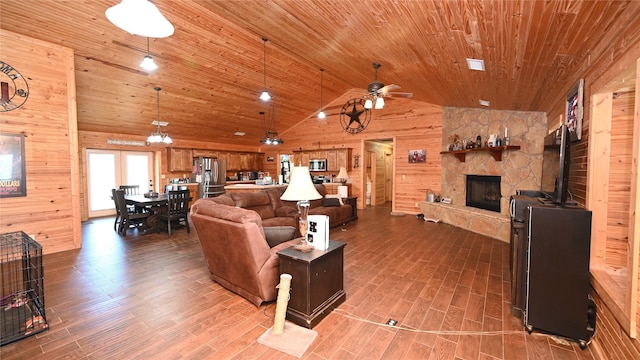 living room featuring wooden walls, wooden ceiling, wood finished floors, a fireplace, and high vaulted ceiling