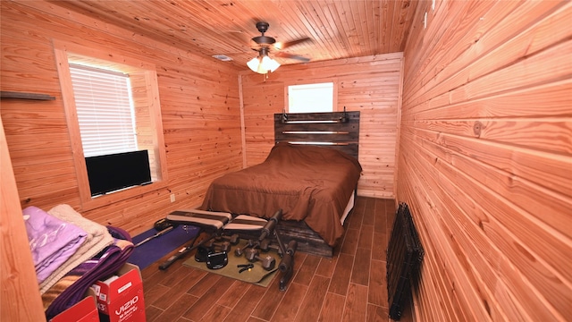 bedroom featuring wood ceiling, wood walls, wood tiled floor, and ceiling fan