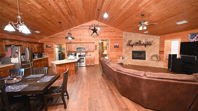 living room featuring vaulted ceiling, wooden ceiling, wood walls, and wood finished floors