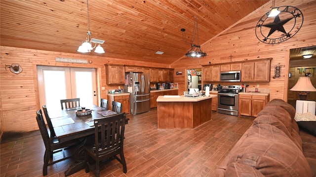 kitchen featuring stainless steel appliances, light countertops, wood ceiling, a kitchen island, and wooden walls