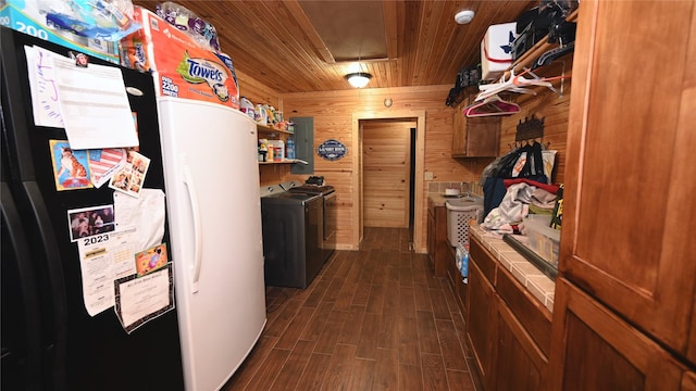 kitchen with tile counters, brown cabinetry, dark wood-style floors, wood ceiling, and wood walls