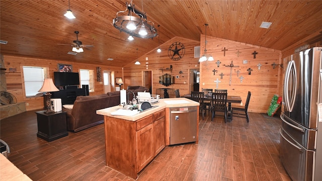 kitchen featuring light countertops, appliances with stainless steel finishes, wood ceiling, wood walls, and vaulted ceiling