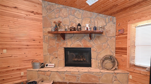 interior details with wooden ceiling, a fireplace, visible vents, and wooden walls