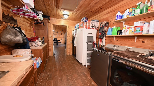 kitchen featuring tile countertops, dark wood-type flooring, wood walls, wood ceiling, and independent washer and dryer