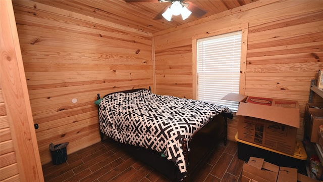 bedroom featuring wood ceiling, wood walls, wood tiled floor, and ceiling fan