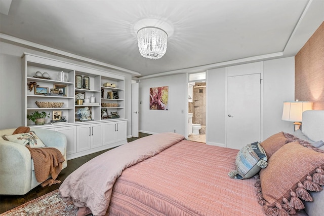 bedroom featuring an inviting chandelier and connected bathroom