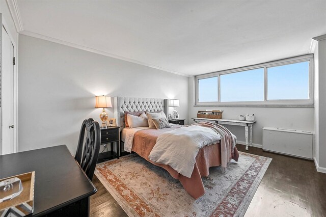 bedroom with baseboards, wood finished floors, and crown molding
