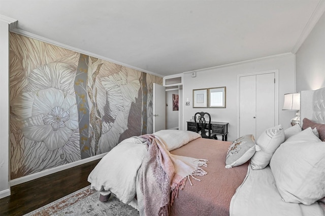 bedroom with baseboards, a closet, ornamental molding, and wood finished floors