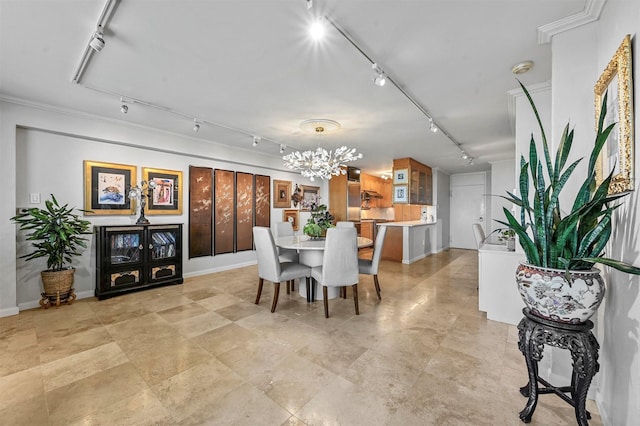 dining room featuring a notable chandelier, baseboards, and track lighting