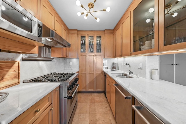 kitchen featuring appliances with stainless steel finishes, backsplash, a sink, and under cabinet range hood