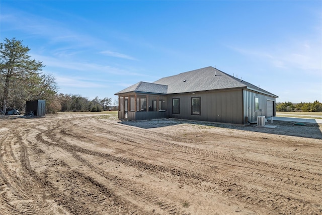 back of property featuring a shingled roof, central AC, and a sunroom