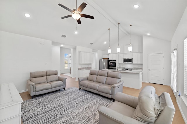 living room featuring ceiling fan, baseboards, high vaulted ceiling, and light wood-style flooring