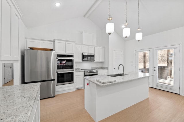 kitchen with light wood finished floors, a sink, french doors, appliances with stainless steel finishes, and white cabinetry