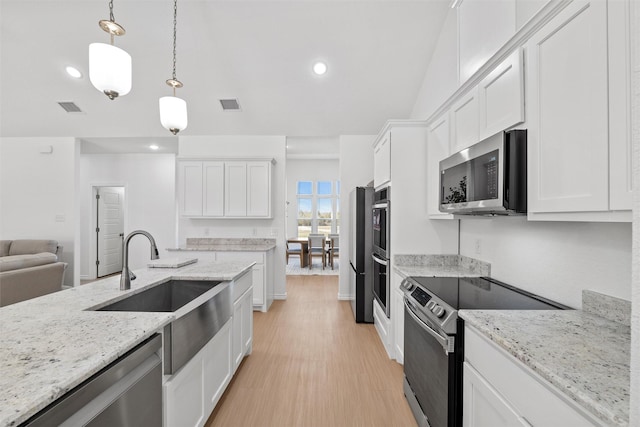 kitchen with visible vents, white cabinets, stainless steel appliances, and a sink