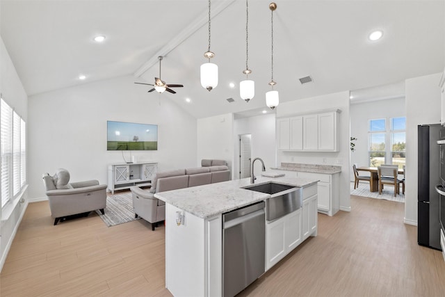 kitchen with dishwasher, light wood-style flooring, open floor plan, and a sink