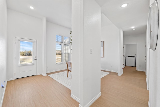 hallway featuring washer and dryer, recessed lighting, light wood-style floors, and baseboards