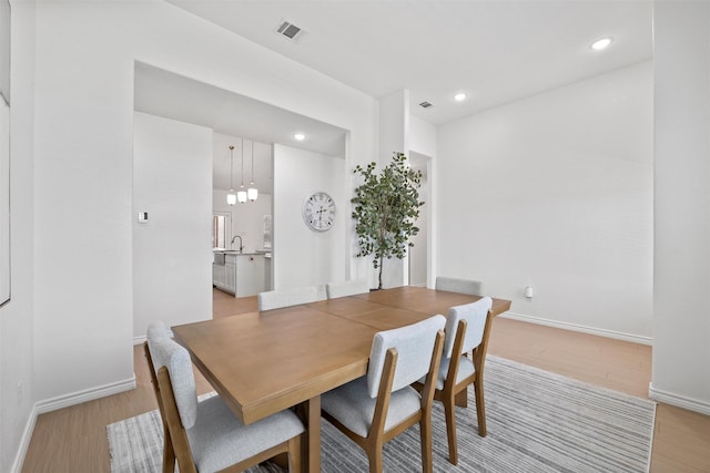 dining room featuring visible vents, baseboards, and light wood-style floors