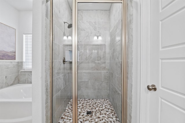 bathroom with a shower stall and a bath