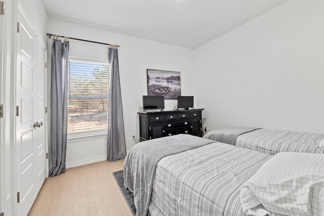 bedroom with baseboards and light wood finished floors