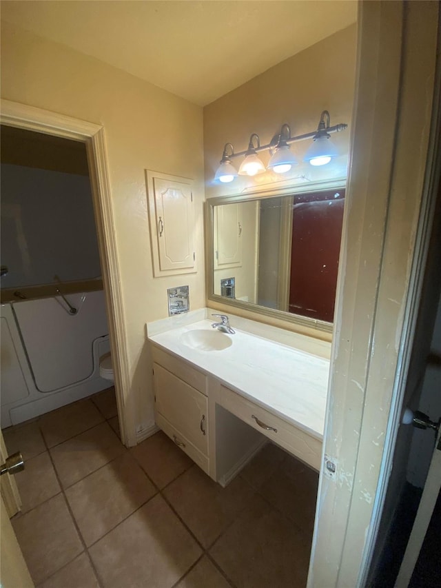 bathroom with toilet, a tub, vanity, and tile patterned floors