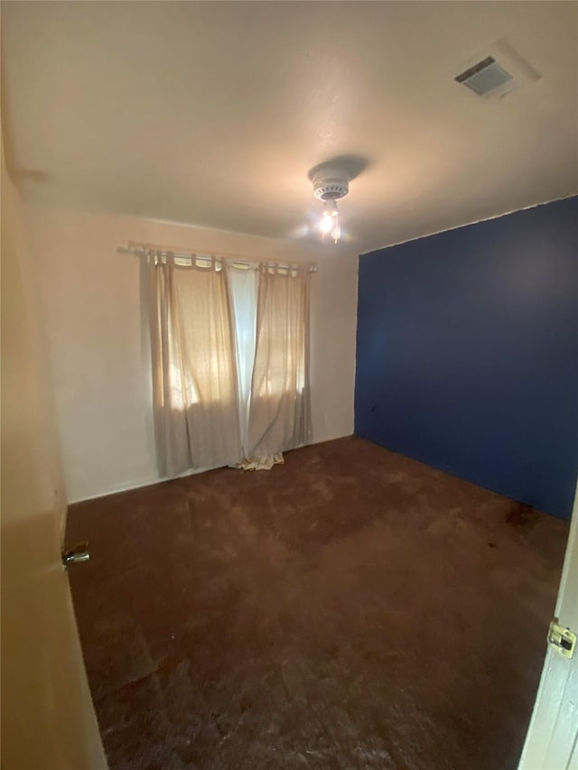 carpeted empty room featuring visible vents