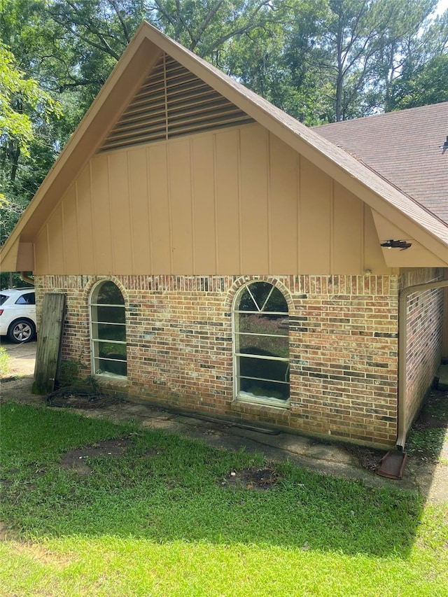 view of property exterior with a yard and brick siding