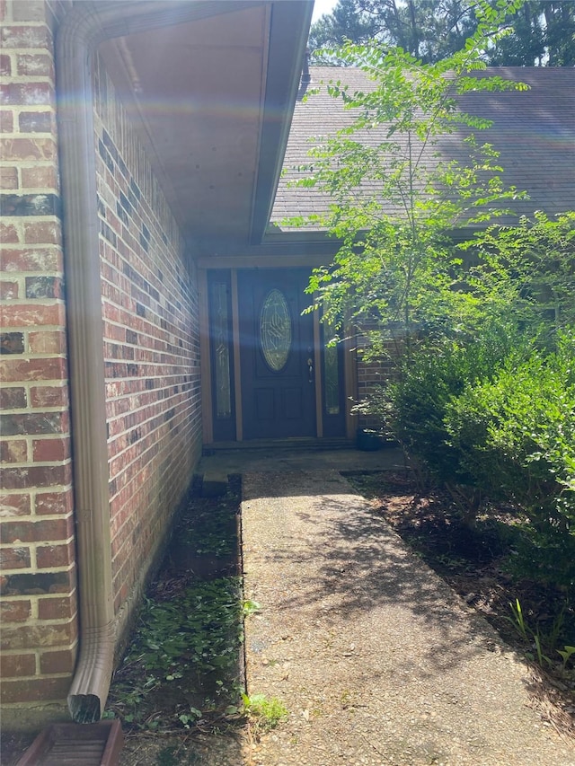 view of exterior entry with brick siding