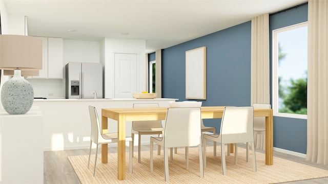 dining area featuring light wood-type flooring and baseboards