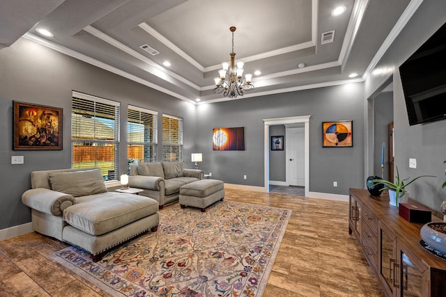 living area featuring visible vents, a tray ceiling, and ornamental molding