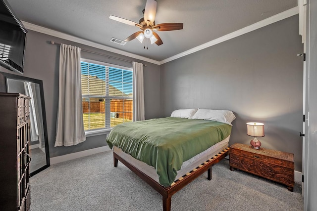 carpeted bedroom featuring visible vents, crown molding, baseboards, and ceiling fan