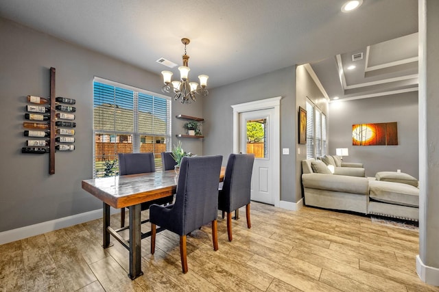 dining space featuring an inviting chandelier, baseboards, light wood-style flooring, and visible vents