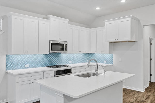 kitchen with stainless steel appliances, tasteful backsplash, light countertops, white cabinetry, and a sink