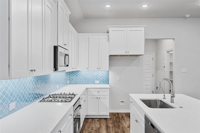 kitchen with white cabinets, dark wood-style flooring, stainless steel appliances, and a sink