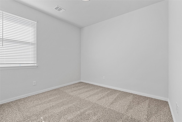 carpeted empty room with visible vents and baseboards